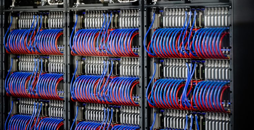 The Aurora super computer. Dozens of nodes can be seen with bright red and blue cables spooling out from the nodes.