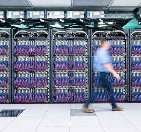 A hazy person in motion walks in front of the Aurora super computer