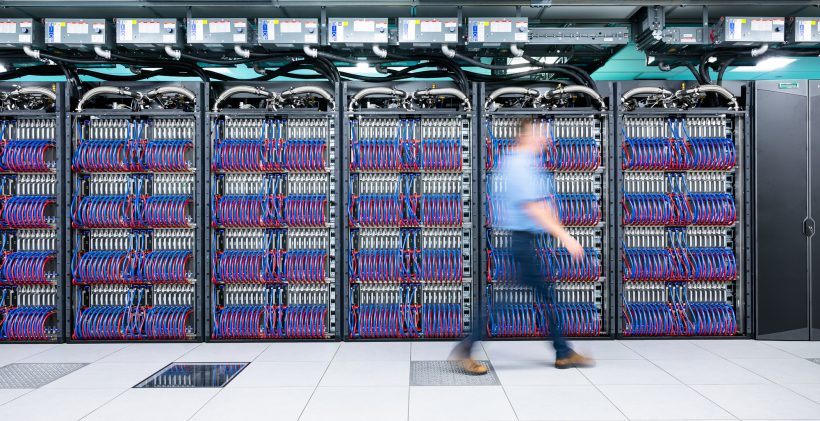 A hazy person in motion walks in front of the Aurora super computer